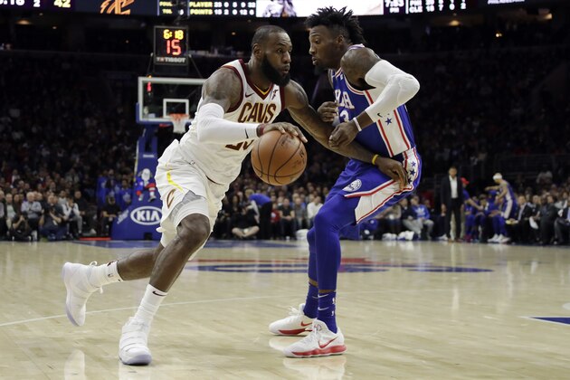Cleveland Cavaliers' LeBron James, left, dribbles past Philadelphia 76ers' Robert Covington during the first half of an NBA basketball game, Monday, Nov. 27, 2017, in Philadelphia. (AP Photo/Matt Slocum)