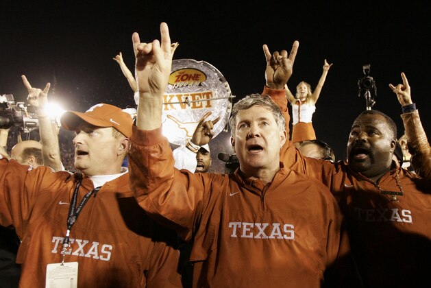 FILE - In this Jan. 4, 2006, file photo, Texas head coach Mack Brown, center, does the hook'em horns sign with the coaching staff after they beat Southern California 41-38 in the Rose Bowl, the national championship college football game, in Pasadena, Calif. (AP Photo/Kevork Djansezian, File)