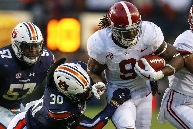 Alabama running back Bo Scarbrough (9) is tackled by Auburn linebacker Tre' Williams (30) as he carries the ball during the second half of the Iron Bowl NCAA college football game, Saturday, Nov. 25, 2017, in Auburn, Ala. (AP Photo/Butch Dill)