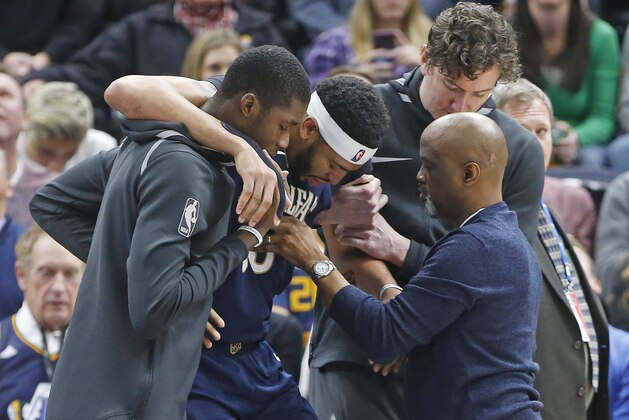 New Orleans Pelicans forward Anthony Davis is helped off the court after being injured in the second half during an NBA basketball game against the Utah Jazz, Friday, Dec. 1, 2017, in Salt Lake City. (AP Photo/Rick Bowmer)