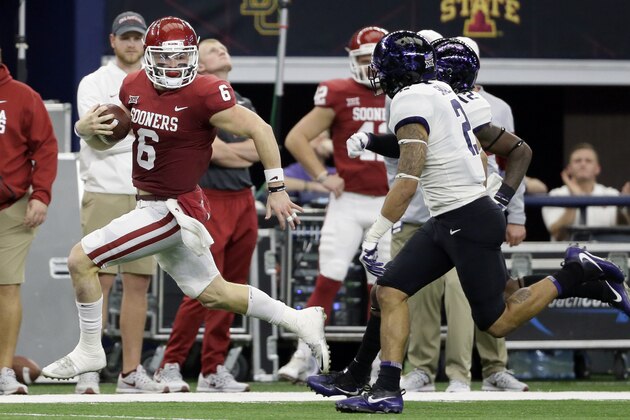 Oklahoma quarterback Baker Mayfield, left, gains yardage as he runs the ball as TCU safety Niko Small (2) gives chase in the first half of the Big 12 Conference championship NCAA college football game, Saturday, Dec. 2, 2017, in Arlington, Texas. (AP Photo/Tony Gutierrez)