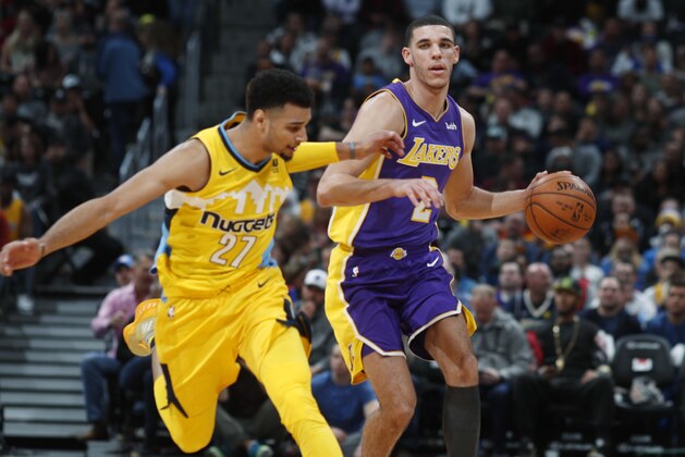 Denver Nuggets guard Jamal Murray, left, loses his footing as he tries to stop Los Angeles Lakers guard Lonzo Ball as he drives upcourt in the first half of an NBA basketball game Saturday, Dec. 2, 2017, in Denver. (AP Photo/David Zalubowski)