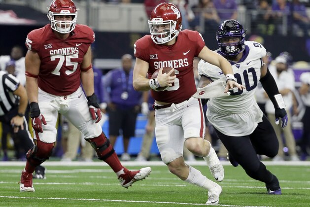 Oklahoma offensive lineman Dru Samia (75) watches as quarterback Baker Mayfield, front, is chased out of the pocket by TCU defensive tackle Ross Blacklock, right, in the second half of the Big 12 Conference championship NCAA college football game, Saturday, Dec. 2, 2017, in Arlington, Texas. (AP Photo/Tony Gutierrez)