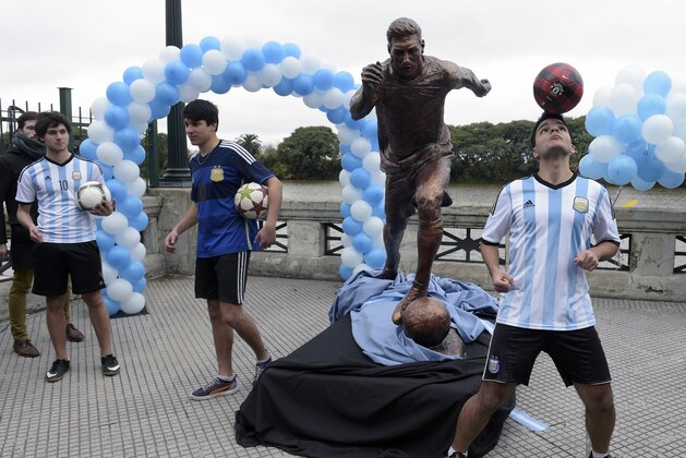 Young play with footballs next to a sculpture of Argentina's forward Lionel Messi, after it unveiling by Buenos Aires Mayor Horacio Rodriguez Larreta in Buenos Aires, Argentina, on June 28, 2016. / AFP / JUAN MABROMATA        (Photo credit should read JUAN MABROMATA/AFP/Getty Images)