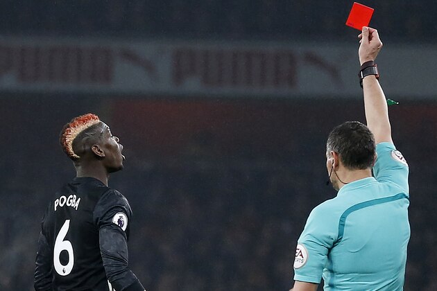 Referee Andre Marriner shows a red card to Manchester United's French midfielder Paul Pogba (L) for his challenge on Arsenal's Spanish defender Hector Bellerin during the English Premier League football match between Arsenal and Manchester United at the Emirates Stadium in London on December 2, 2017.  / AFP PHOTO / IKIMAGES / Ian KINGTON / RESTRICTED TO EDITORIAL USE. No use with unauthorized audio, video, data, fixture lists, club/league logos or 'live' services. Online in-match use limited to 45 images, no video emulation. No use in betting, games or single club/league/player publications.        (Photo credit should read IAN KINGTON/AFP/Getty Images)