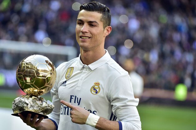 Real Madrid's Portuguese forward Cristiano Ronaldo poses with the Ballon d'Or France Football trophy before the Spanish league football match Real Madrid CF vs Granada FC at the Santiago Bernabeu stadium in Madrid on January 7, 2017. / AFP / GERARD JULIEN        (Photo credit should read GERARD JULIEN/AFP/Getty Images)