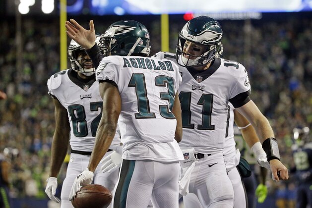 Philadelphia Eagles quarterback Carson Wentz (11) congratulates Nelson Agholor (13) on his touchdown reception against the Seattle Seahawks during the second half of an NFL football game, Sunday, Dec. 3, 2017, in Seattle. (AP Photo/Ted S. Warren)
