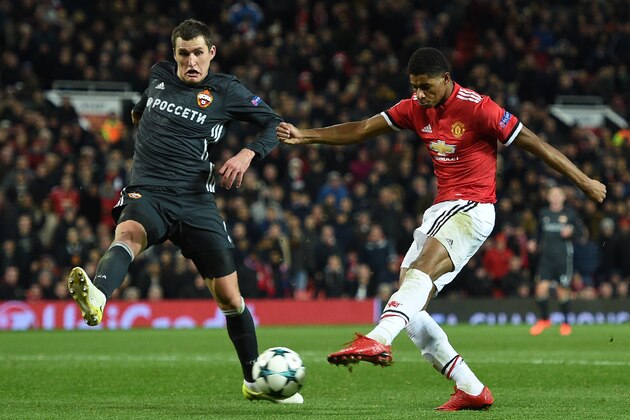 Manchester United's English striker Marcus Rashford (R) shoots under pressure from CSKA Moscow's Russian defender Viktor Vasin (L) to score their second goal during the UEFA Champions League Group A football match between Manchester United and CSKA Moscow at Old Trafford in Manchester, north west England on December 5, 2017. / AFP PHOTO / Oli SCARFF        (Photo credit should read OLI SCARFF/AFP/Getty Images)