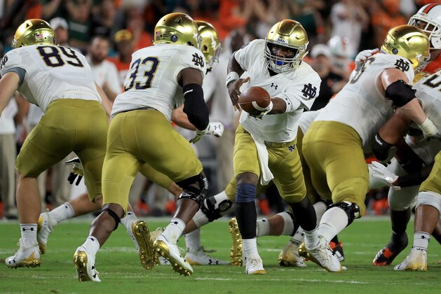 MIAMI GARDENS, FL - NOVEMBER 11:  Brandon Wimbush #7 of the Notre Dame Fighting Irish hands off to Josh Adams #33 during a game against the Miami Hurricanes at Hard Rock Stadium on November 11, 2017 in Miami Gardens, Florida.  (Photo by Mike Ehrmann/Getty Images)