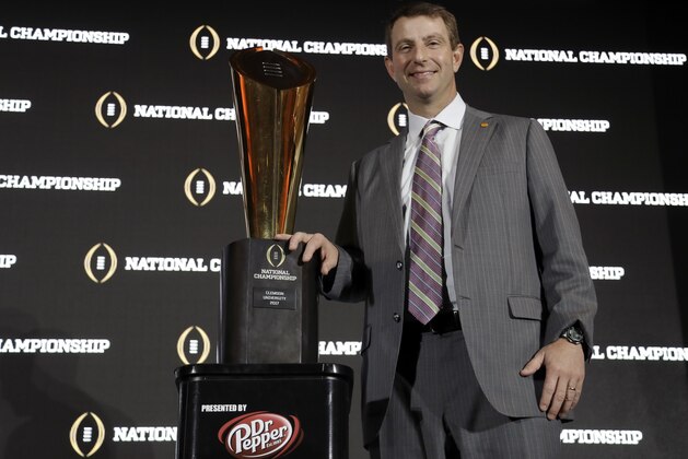 Clemson head coach Dabo Swinney poses with the championship trophy after an NCAA college football news conference Tuesday, Jan. 10, 2017, in Tampa, Fla. Clemson defeated Alabama 35-31 in the College Football Playoff National Championship Game. (AP Photo/Chris O'Meara)