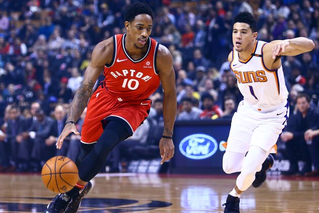 TORONTO, ON - December 05:  DeMar DeRozan #10 of the Toronto Raptors dribbles the ball as Devin Booker #1 of the Phoenix Suns defends during the first half of an NBA game at Air Canada Centre on December 5, 2017 in Toronto, Canada.  NOTE TO USER: User expressly acknowledges and agrees that, by downloading and or using this photograph, User is consenting to the terms and conditions of the Getty Images License Agreement.  (Photo by Vaughn Ridley/Getty Images)