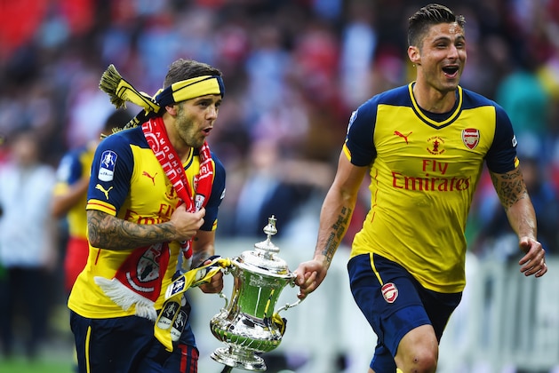 LONDON, ENGLAND - MAY 30:  Jack Wilshere and Olivier Giroud of Arsenal celebrate victory with the trophy after the FA Cup Final between Aston Villa and Arsenal at Wembley Stadium on May 30, 2015 in London, England. Arsenal beat Aston Villa 4-0.  (Photo by Shaun Botterill/Getty Images)