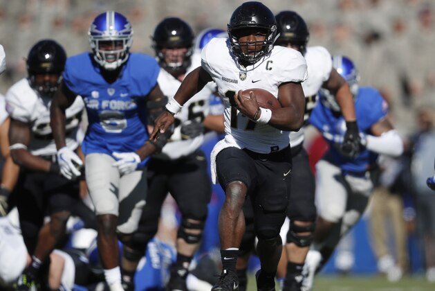 FILE - In this Saturday, Nov. 4, 2017, file photo, Army quarterback Ahmad Bradshaw breaks from the line of scrimmage against Air Force while running an option play in the first half of an NCAA college football game at Air Force Academy, Colo. The triple option has been part of the DNA for Air Force, Navy and Army for decades because it levels the playing field. It's hard to defend and doesn't require big offensive linemen. At its core, the system is centered on a quarterback with plenty of moxie and a fullback with a nose for getting through a tiny crease.  (AP Photo/David Zalubowski, File)