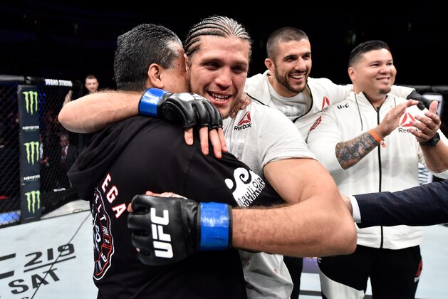 FRESNO, CA - DECEMBER 09:  Brian Ortega hugs his dad after his submission victory over Cub Swanson in their featherweight bout during the UFC Fight Night event inside Save Mart Center on December 9, 2017 in Fresno, California. (Photo by Jeff Bottari/Zuffa LLC/Zuffa LLC via Getty Images)