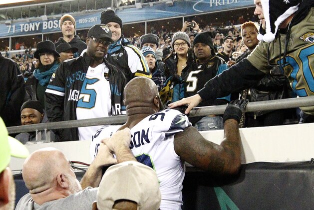 Seattle Seahawks defensive tackle Quinton Jefferson, center, tries to climb up in the stands after Jacksonville Jaguars fans threw objects at him in the closing moments of an NFL football game, Sunday, Dec. 10, 2017, in Jacksonville, Fla. Jacksonville won 30-24. (AP Photo/Stephen B. Morton)