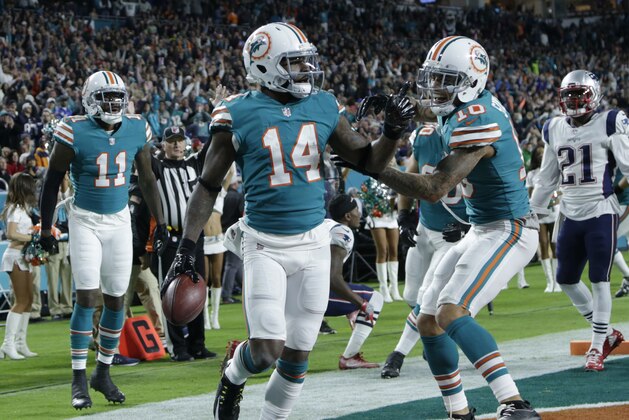 Miami Dolphins wide receiver Kenny Stills (10) congratulates wide receiver Jarvis Landry (14) after Landry scored a touchdown, during the first half of an NFL football game against the New England Patriots, Monday, Dec. 11, 2017, in Miami Gardens, Fla. (AP Photo/Lynne Sladky)