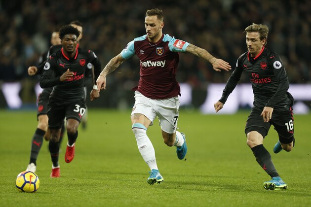 West Ham United's Austrian midfielder Marko Arnautovic (C) holds off Arsenal's Spanish defender Nacho Monreal (R) during the English Premier League football match between West Ham United and Arsenal at The London Stadium, in east London on December 13, 2017. / AFP PHOTO / Ian KINGTON / RESTRICTED TO EDITORIAL USE. No use with unauthorized audio, video, data, fixture lists, club/league logos or 'live' services. Online in-match use limited to 75 images, no video emulation. No use in betting, games or single club/league/player publications. / (Photo credit should read IAN KINGTON/AFP/Getty Images) West Ham United's Austrian midfielder Marko Arnautovic (C) holds off Arsenal's Spanish defender Nacho Monreal (R) during the English Premier League football match between West Ham United and Arsenal at The London Stadium, in east London on December 13, 2017. / AFP PHOTO / Ian KINGTON / RESTRICTED TO EDITORIAL USE. No use with unauthorized audio, video, data, fixture lists, club/league logos or 'live' services. Online in-match use limited to 75 images, no video emulation. No use in betting, games or single club/league/player publications. / (Photo credit should read IAN KINGTON/AFP/Getty Images)