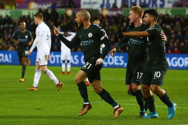 Manchester City's Spanish midfielder David Silva (L) celebrates after scoring with Manchester City's Argentinian striker Sergio Aguero and Manchester City's Belgian midfielder Kevin De Bruyne during the English Premier League football match between Swansea City and Manchester City at The Liberty Stadium in Swansea, south Wales on December 13, 2017. / AFP PHOTO / Geoff CADDICK / RESTRICTED TO EDITORIAL USE. No use with unauthorized audio, video, data, fixture lists, club/league logos or 'live' services. Online in-match use limited to 75 images, no video emulation. No use in betting, games or single club/league/player publications.  /         (Photo credit should read GEOFF CADDICK/AFP/Getty Images)