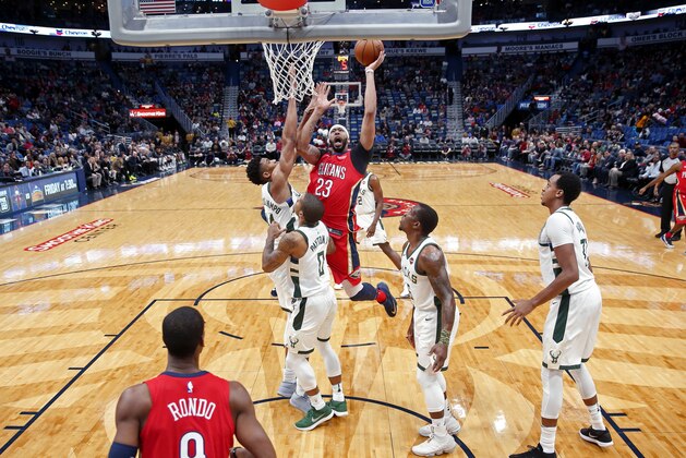 New Orleans Pelicans forward Anthony Davis (23) goes to the basket against Milwaukee Bucks forward Giannis Antetokounmpo in the first half of an NBA basketball game in New Orleans, Wednesday, Dec. 13, 2017. (AP Photo/Gerald Herbert)