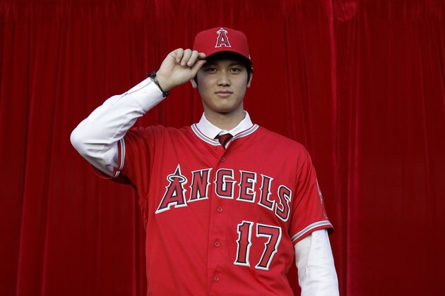 Baseball player Shohei Ohtani, of Japan, poses for photos after a news conference at Angel Stadium, Saturday, Dec. 9, 2017, in Anaheim, Calif. The Japanese star is bringing his arm and bat to the Los Angeles Angels, pairing him with two-time MVP Mike Trout. (AP Photo/Jae C. Hong)