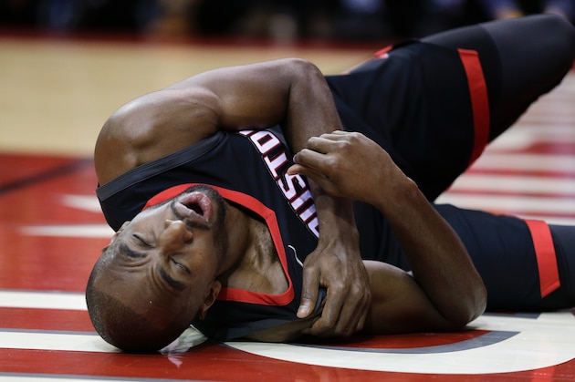 HOUSTON, TX - DECEMBER 13:  Luc Mbah a Moute #12 of the Houston Rockets lays on the court after he injured himself driving to the baskewt in the second quarter against the Charlotte Hornets at Toyota Center on December 13, 2017 in Houston, Texas. NOTE TO USER: User expressly acknowledges and agrees that, by downloading and or using this photograph, User is consenting to the terms and conditions of the Getty Images License Agreement.  (Photo by Bob Levey/Getty Images)