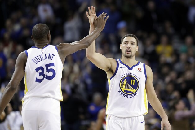 Golden State Warriors' Klay Thompson (11) high fives teammate Kevin Durant during the second half of an NBA basketball game against the Portland Trail Blazers Monday, Dec. 11, 2017, in Oakland, Calif. (AP Photo/Marcio Jose Sanchez)