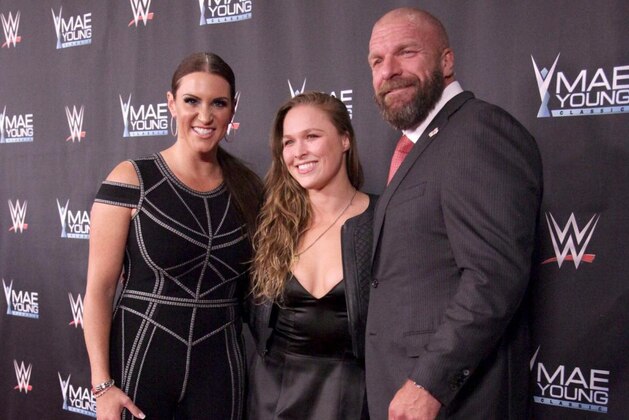 Ronda Rousey with Triple H and Stephanie McMahon.