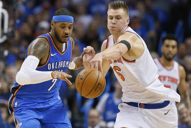 Oklahoma City Thunder forward Carmelo Anthony (7) and New York Knicks forward Kristaps Porzingis (6) reach for the ball in the second quarter of an NBA basketball game in Oklahoma City, Thursday, Oct. 19, 2017. (AP Photo/Sue Ogrocki)