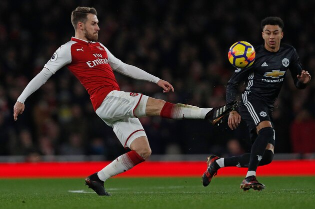 Arsenal's Welsh midfielder Aaron Ramsey (L) vies with Manchester United's English midfielder Jesse Lingard during the English Premier League football match between Arsenal and Manchester United at the Emirates Stadium in London on December 2, 2017.  / AFP PHOTO / Adrian DENNIS / RESTRICTED TO EDITORIAL USE. No use with unauthorized audio, video, data, fixture lists, club/league logos or 'live' services. Online in-match use limited to 75 images, no video emulation. No use in betting, games or single club/league/player publications.  /         (Photo credit should read ADRIAN DENNIS/AFP/Getty Images)