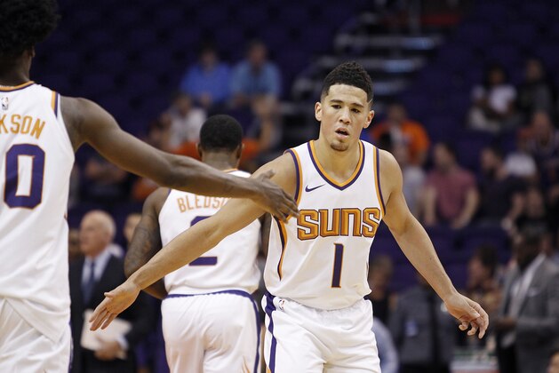 Phoenix Suns guard Devin Booker (1) is congratulated by teammate Josh Jackson during a timeout in an NBA basketball exhibition game against Australia's Brisbane Bullets Friday, Oct. 13, 2017, in Phoenix. The Suns defeated the Bullets 114-93. (AP Photo/Ralph Freso)