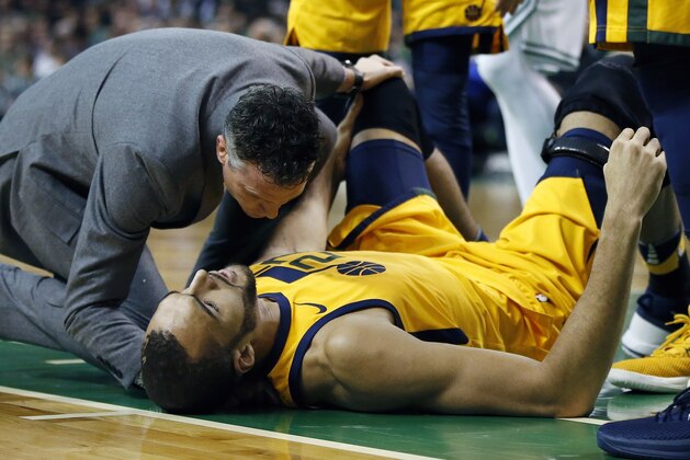 Utah Jazz's Rudy Gobert lies on the court after being injured during the first quarter of an NBA basketball game against the Boston Celtics in Boston, Friday, Dec. 15, 2017. (AP Photo/Michael Dwyer)