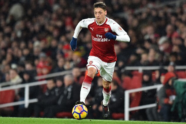 Arsenal's German midfielder Mesut Ozil runs with the ball during the English Premier League football match between Arsenal and Newcastle United at the Emirates Stadium in London on December 16, 2017.  / AFP PHOTO / Glyn KIRK / RESTRICTED TO EDITORIAL USE. No use with unauthorized audio, video, data, fixture lists, club/league logos or 'live' services. Online in-match use limited to 75 images, no video emulation. No use in betting, games or single club/league/player publications.  /         (Photo credit should read GLYN KIRK/AFP/Getty Images)