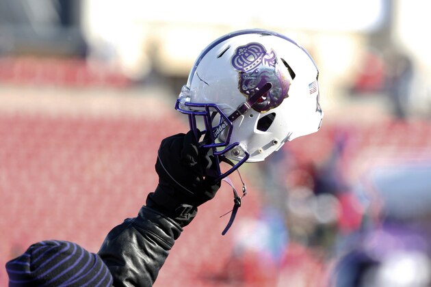 A member of the staff holds up a James Madison helmet during the FCS championship NCAA college football game against Youngstown State on Saturday, Jan. 7, 2017, in Frisco, Texas. (AP Photo/Sarah Warnock)