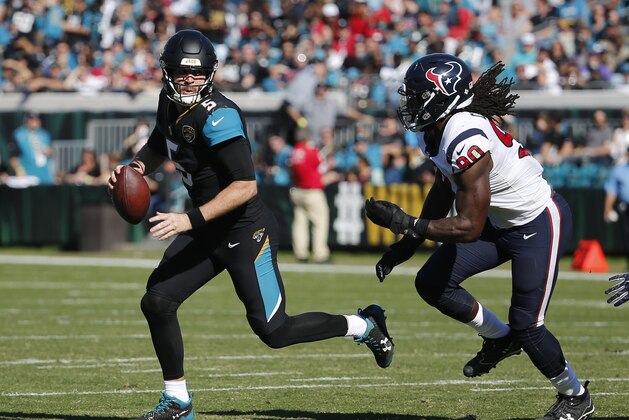 Jacksonville Jaguars quarterback Blake Bortles, left, looks for a receiver as he is pressured by Houston Texans defensive end Jadeveon Clowney (90) during the first half of an NFL football game, Sunday, Dec. 17, 2017, in Jacksonville, Fla. (AP Photo/Stephen B. Morton)