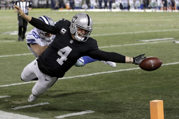 Derek Carr, quarterback de los Raiders de Oakland, suelta el balón antes de llegar a la zona de anotación, frente a Jeff Heath, de los Cowboys de Dallas, el domingo 17 de diciembre de 2017 (AP Foto/Ben Margot)