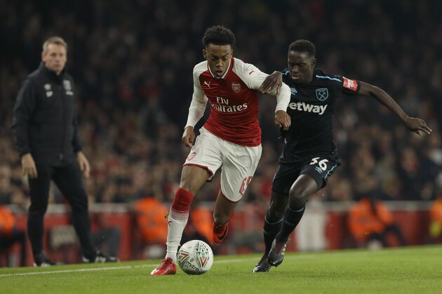 Arsenal's Joe Willock, left, holds off the challenge of West Ham United's Domingos Quina during the English League Cup quarterfinal soccer match between Arsenal and West Ham United at the Emirates stadium in London, Tuesday, Dec. 19, 2017. (AP Photo/Alastair Grant)