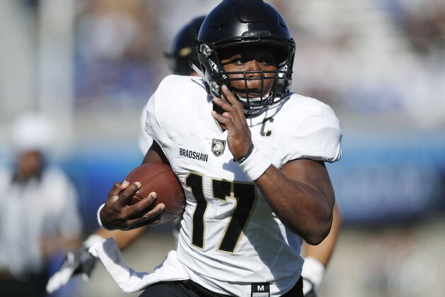 FILE - In this Nov. 4, 2017, file photo, Army quarterback Ahmad Bradshaw runs past Air Force defenders for a touchdown in the first half of an NCAA college football game, at Air Force Academy, Colo. The Black Knights (8-3) enter the 118th meeting with Navy on Saturday as a bowl-bound team again, holding a better record than the Midshipmen (6-5) for the first time since 2001. (AP Photo/David Zalubowski, File)