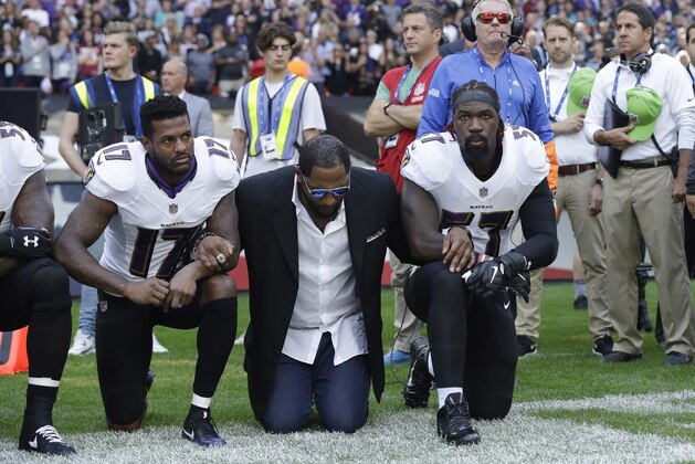 FILE - In this Sunday Sept. 24, 2017, file photo, Baltimore Ravens wide receiver Mike Wallace, from left, former player Ray Lewis and inside linebacker C.J. Mosley lock arms and kneel down during the playing of the U.S. national anthem before an NFL football game against the Jacksonville Jaguars at Wembley Stadium in London. People have signed an online petition asking for the removal of a statute of Lewis after he joined other NFL players kneeling during the national anthem. (AP Photo/Matt Dunham, File)