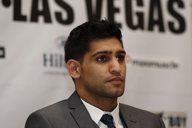 British Boxer Amir Khan poses for the photographers following a news conference in London, Tuesday, March 13, 2012. Light Welterweight World Champion US boxer Lamont Peterson will defends his WBA and IBF light-welterweight titles against British challenger Khan in a rematch of their disputed fight last year on May 19, 2012  Las Vegas. Khan lost both belts in a split-decision loss to the American on Dec. 10. But he complained about the referee's decision to deduct two points for pushing and the presence of an unauthorized man at ringside seen distracting an official. (AP Photo/Lefteris Pitarakis)