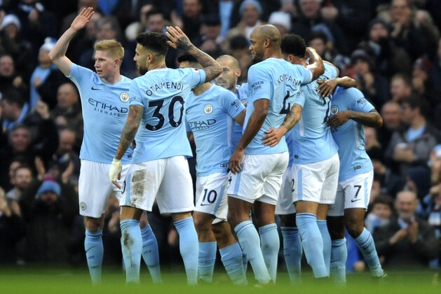 Manchester City's players celebrate after Manchester City's Sergio Aguero, obscured, scored his side's first goal during the English Premier League soccer match between Manchester City and Bournemouth at Etihad stadium, in Manchester, England, Saturday, Dec. 23, 2017. (AP Photo/Rui Vieira)