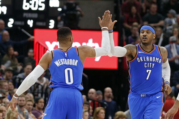 Oklahoma City Thunder's Russell Westbrook (0) receives a high-five from teammate Carmelo Anthony (7) after scoring three-point basket against the Utah Jazz in the second half during an NBA basketball game Saturday, Dec. 23, 2017, in Salt Lake City. (AP Photo/Rick Bowmer)