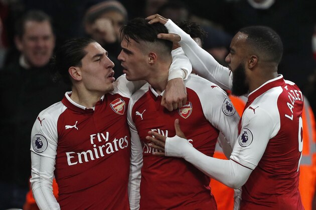 Arsenal's Swiss midfielder Granit Xhaka (C) celebrates scoring the team's second goal with teammates during the English Premier League football match between Arsenal and Liverpool at the Emirates Stadium in London on December 22, 2017.  / AFP PHOTO / Adrian DENNIS / RESTRICTED TO EDITORIAL USE. No use with unauthorized audio, video, data, fixture lists, club/league logos or 'live' services. Online in-match use limited to 75 images, no video emulation. No use in betting, games or single club/league/player publications.  /         (Photo credit should read ADRIAN DENNIS/AFP/Getty Images)
