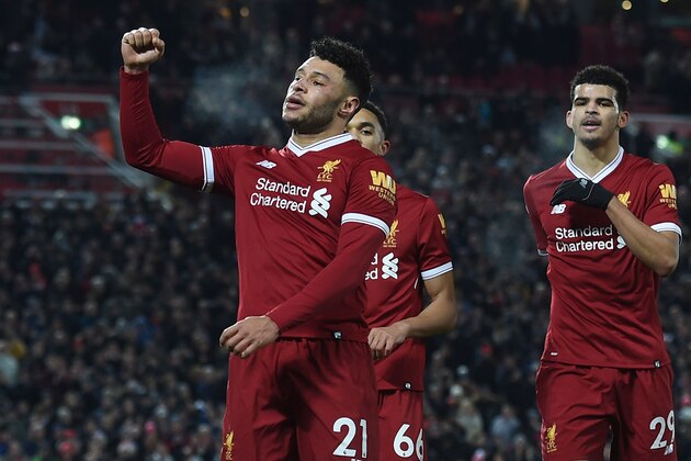 Liverpool's English midfielder Alex Oxlade-Chamberlain (L) celebrates scoring their fifth goal with Liverpool's English midfielder Trent Alexander-Arnold (C) and Liverpool's English striker Dominic Solanke (R) during the English Premier League football match between Liverpool and Swansea City at Anfield in Liverpool, north west England on December 26, 2017. / AFP PHOTO / PAUL ELLIS / RESTRICTED TO EDITORIAL USE. No use with unauthorized audio, video, data, fixture lists, club/league logos or 'live' services. Online in-match use limited to 75 images, no video emulation. No use in betting, games or single club/league/player publications.  /         (Photo credit should read PAUL ELLIS/AFP/Getty Images)