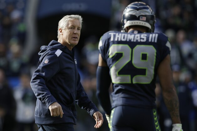 Seattle Seahawks head coach Pete Carroll talks with Seattle Seahawks free safety Earl Thomas before an NFL football game against the Tampa Bay Buccaneers, Sunday, Nov. 3, 2013, in Seattle. (AP Photo/Stephen Brashear)