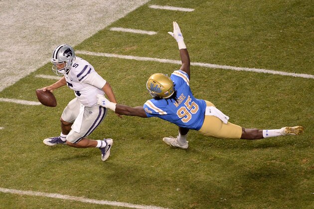 PHOENIX, AZ - DECEMBER 26:  Quarterback Alex Delton #5 of the Kansas State Wildcats avoids a tackle from defensive lineman Marcus Moore #95 of the UCLA Bruins in the second half of the Cactus Bowl at Chase Field on December 26, 2017 in Phoenix, Arizona.  (Photo by Jennifer Stewart/Getty Images)