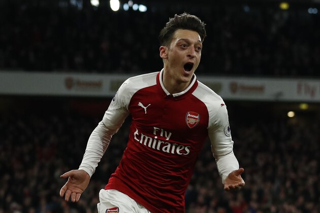 Arsenal's German midfielder Mesut Ozil celebrates scoring the team's second goal during the English Premier League football match between Arsenal and Liverpool at the Emirates Stadium in London on December 22, 2017.  / AFP PHOTO / Adrian DENNIS / RESTRICTED TO EDITORIAL USE. No use with unauthorized audio, video, data, fixture lists, club/league logos or 'live' services. Online in-match use limited to 75 images, no video emulation. No use in betting, games or single club/league/player publications.  /         (Photo credit should read ADRIAN DENNIS/AFP/Getty Images)