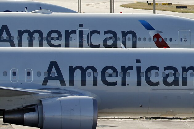 FILE - In this Monday, Nov. 6, 2017, file photo, a pair of American Airlines jets are parked on the airport apron at Miami International Airport in Miami. A scheduling glitch has left American scrambling to find pilots to operate thousands of flights over the busy Christmas holiday period. American said Wednesday, Nov. 29, 2017, it expects to avoid canceling flights by paying overtime and using reserve pilots. (AP Photo/Wilfredo Lee, File)