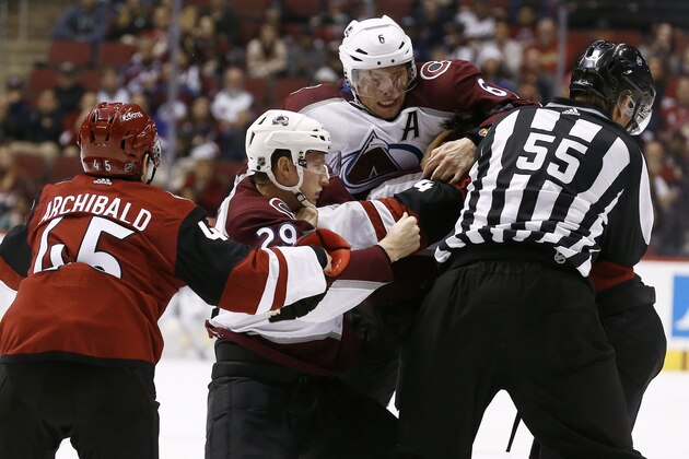 Arizona Coyotes right wing Josh Archibald (45) tries to help out center Zac Rinaldo, back right, as Colorado Avalanche center Nathan MacKinnon (29) and defenseman Erik Johnson (6) both go after Rinaldo as linesman Shane Heyer (55) attempts to break up the fight during the second period of an NHL hockey game, Saturday, Dec. 23, 2017, in Glendale, Ariz. (AP Photo/Ross D. Franklin)