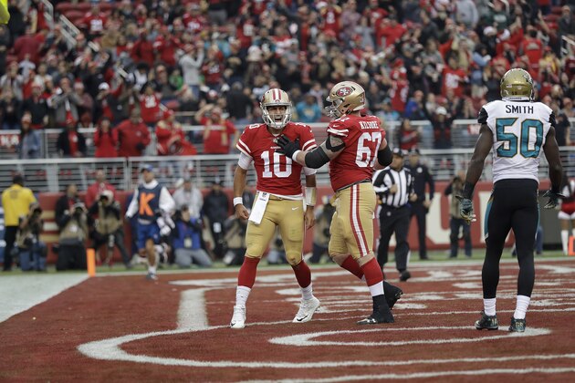 San Francisco 49ers quarterback Jimmy Garoppolo (10) celebrates after scoring a touchdown with center Daniel Kilgore (67) during the first half of an NFL football game against the Jacksonville Jaguars in Santa Clara, Calif., Sunday, Dec. 24, 2017. (AP Photo/Marcio Jose Sanchez)