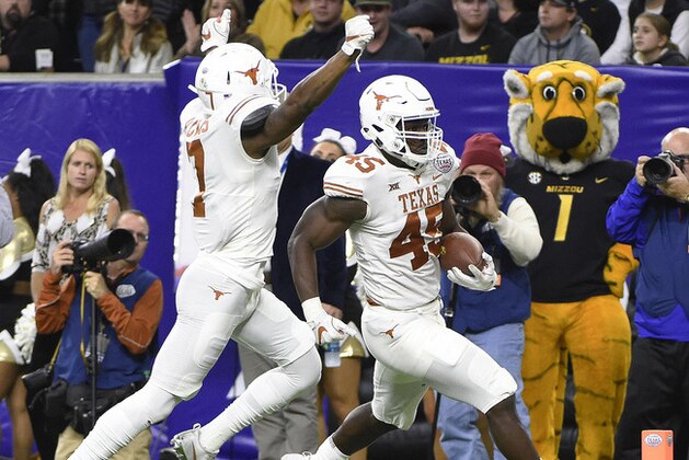 Texas linebacker Anthony Wheeler (45) runs into the end zone for a touchdown after a fumble recovery, as Antwuan Davis celebrates during the first half against Missouri in the Texas Bowl NCAA college football game Wednesday, Dec. 27, 2017, in Houston. (AP Photo/Eric Christian Smith)